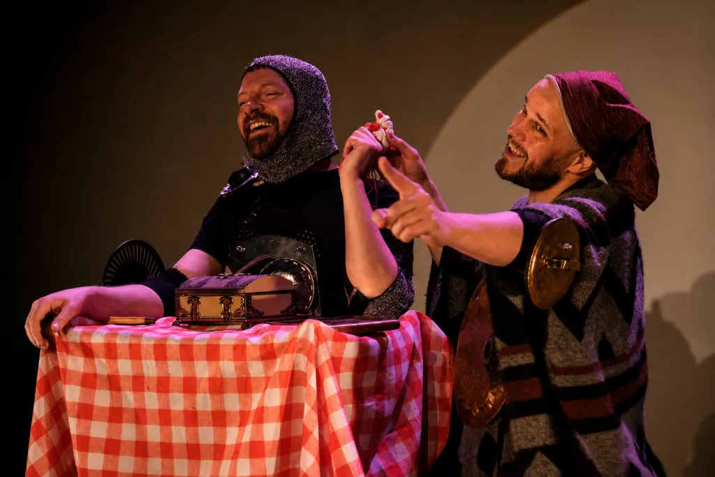 Photo de deux comédiens costumés en chevalier, en train de rire