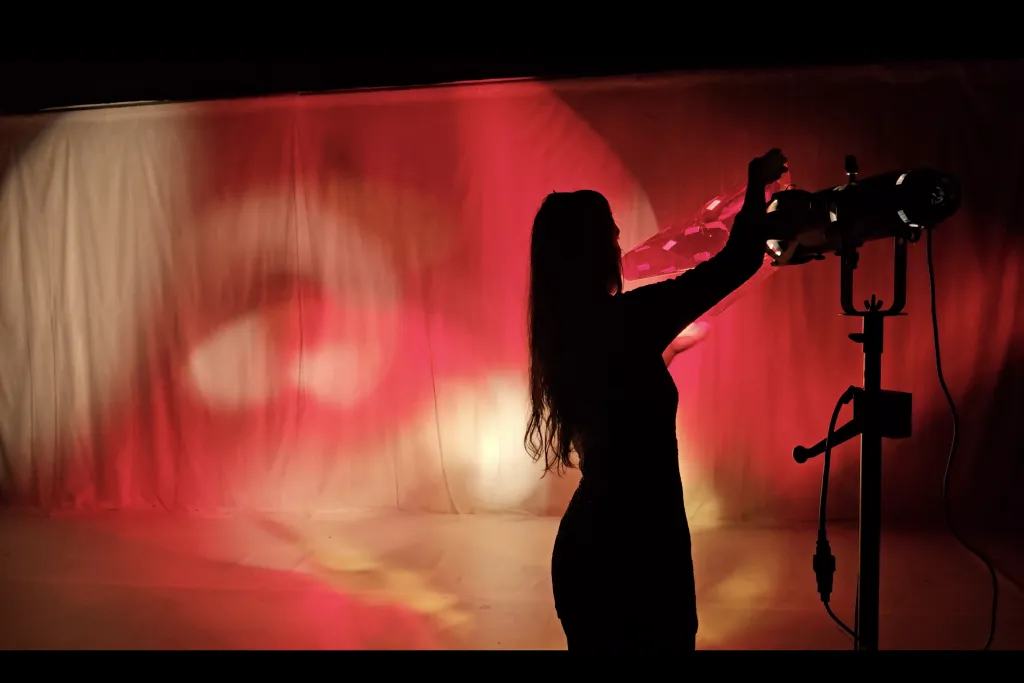 Photo d'une comédienne manipulant un projecteur lumière