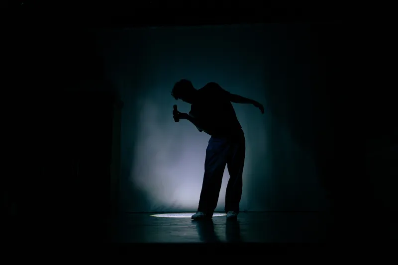 Une silhouette avec en fond un halo de lumière. 