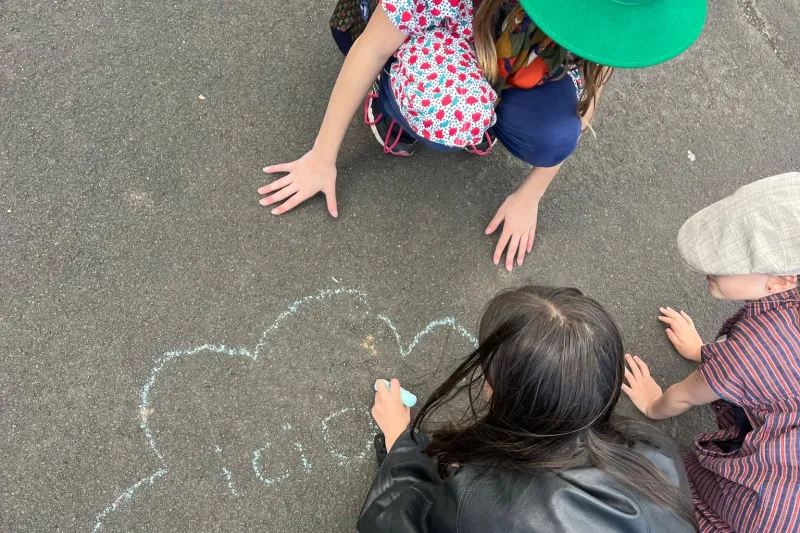 Photo d'un enfant qui dessine à la craie sur le sol