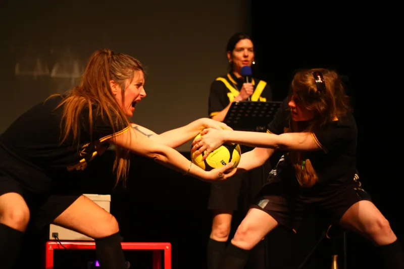 Photo de deux comédiennes en tenue de foot qui se dispute un ballon