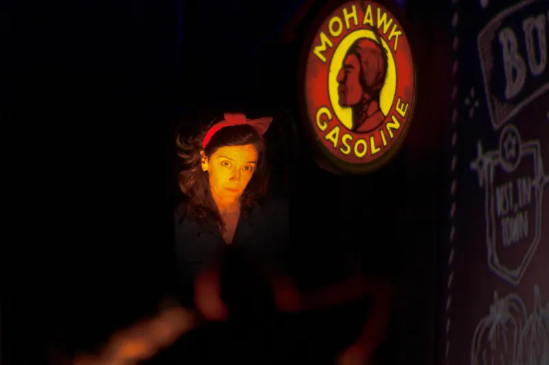 Actrice en Blanche-Neige et enseigne luminuse de station service