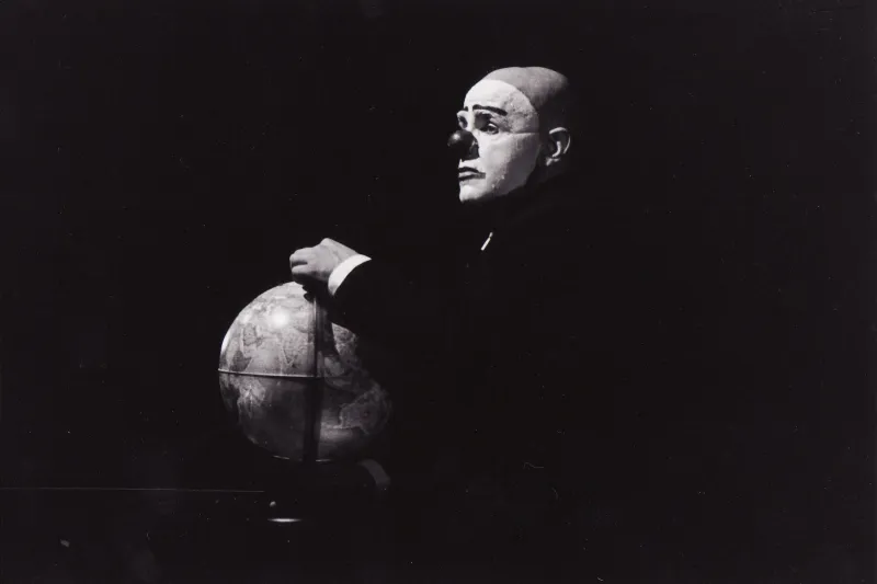 Photo en noir et blanc d'un clown avec un globe terrestre