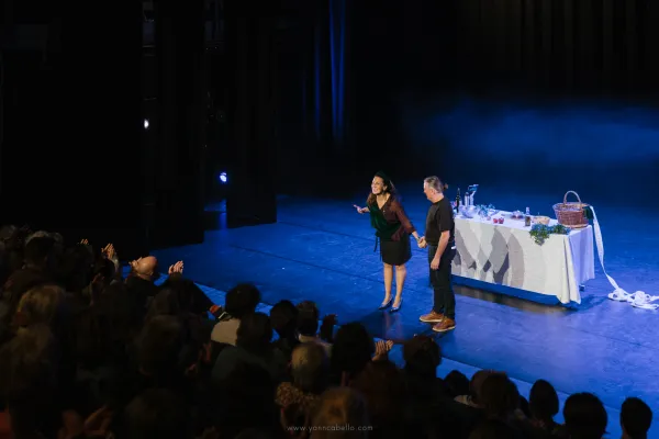Photo de deux personnes saluant le public qui applaudit