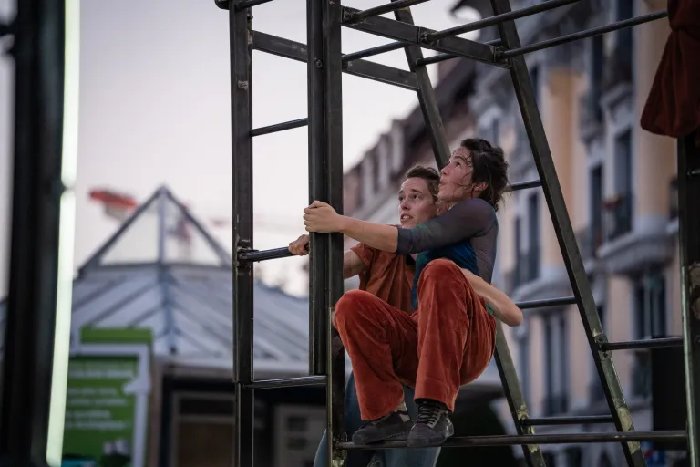 Deux acrobates accrochées à une structure métallique