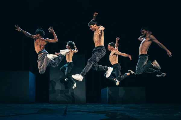 Photo de cinq danseurs en plein saut
