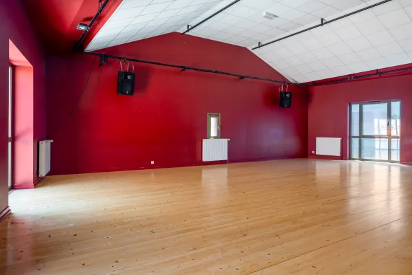 Photo de la salle Mnouchkine, studio de répétition doté d'un plancher et  de plusieurs fenêtres. 
