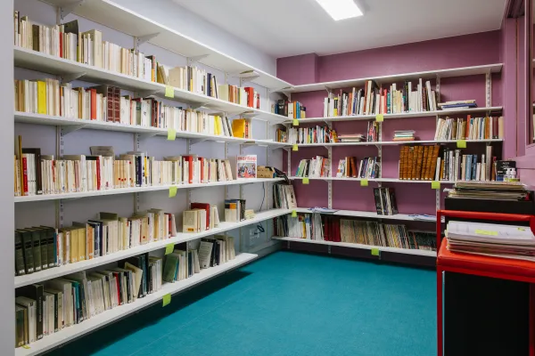Photo d'une pièce avec des étagères de livres sur le mur de droite et le mur d'en face. 